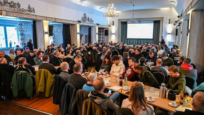 Vollbesetzter, heller Festsaal im Hotel & Restaurant Am Huntepadd während einer Präsenzveranstaltung der Landwirtschaftskammer Niedersachsen mit Blick auf die Leinwand und konzentrierte Teilnehmer an den Tischen.