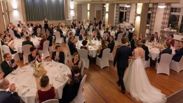 Hochzeit im Festsaal des Hotel & Restaurant am Huntepadd in Dötlingen mit Brautpaar beim Einzug und festlich gedeckten Tischen