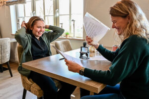 Louise Kelle und Katja Radvan lachen bei der Unterzeichnung des Ausbildungsvertrags im Huntepadd