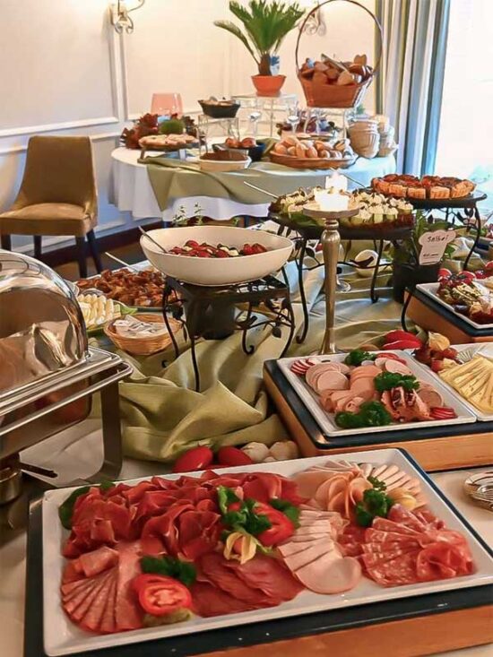 Reichhaltiges Frühstücksbuffet mit Aufschnitt, Käse, Brötchen, Obst und weiteren Speisen im Hotel & Restaurant am Huntepadd